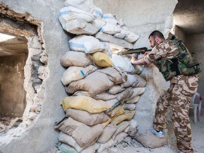 Un sargento del Ej&eacute;rcito sirio se mantiene apostado en un edificio del barrio de Karmel el Jebel, en Alepo