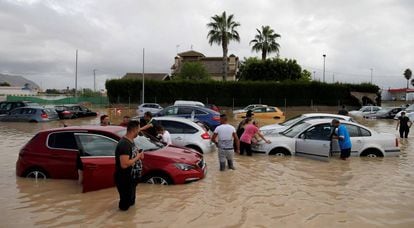 Un grupo de vecinos intenta mover sus vehículos atrapados por las inundaciones en Orihuela (Alicante) en 2019. 