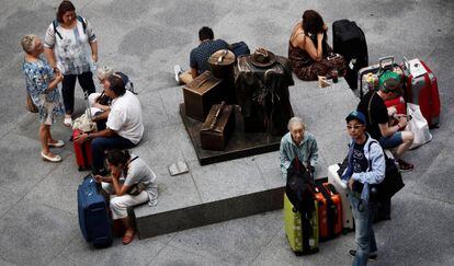 Una decena de viajeros espera en la estación de Atocha de Madrid.