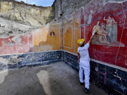 Un arqueólogo muestra algunos de los nuevos frescos descubiertos en Pompeya.