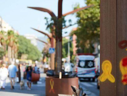 Varias personas pasan ante unos lazos amarillos en el barrio de Sants de Barcelona la semana pasada.