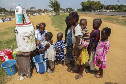 Una voluntaria del programa Mujeres en Paz lava las manos a unos niños liberianos para tratar evitar el contagio del ébola en Monrovia (Liberia). El banco mundial ha dispuesto de 200 millones de dólares para la asistencia de emergencia de aquellos países golpeados por la enfermedad: Sierra Leona, Guinea y Liberia.