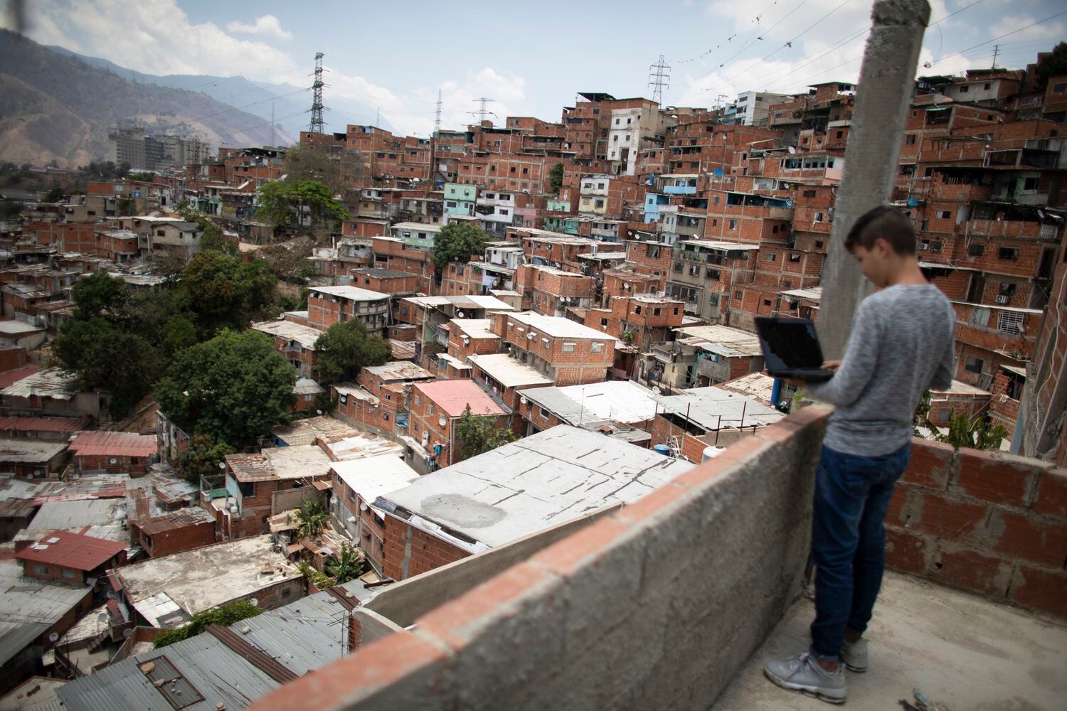 Un estudiante adolescente intenta conectarse a internet desde la azotea de su casa en Caracas, Venezuela, el 7 de mayo.