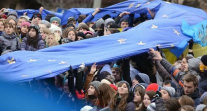 Decenas de estudiantes sostienen una enorme bandera de la UE.