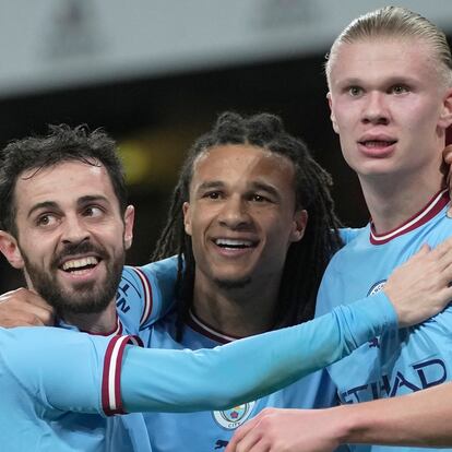 Manchester City's Erling Haaland, right, celebrates after scoring with Manchester City's Bernardo Silva, left, and Manchester City's Nathan Ake during the English Premier League soccer match between Arsenal and Manchester City at the Emirates stadium in London, England, Wednesday, Feb.15, 2023. (AP Photo/Kin Cheung)