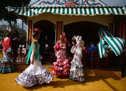 A woman wearing a traditional Sevillian dress poses for a picture during the "Feria de Abril" (April Fair) in Sevilla on April 30, 2017. 
The fair dates back to 1847 when it was originally organized as a livestock fair but has turned into a week of flamenco dancing, music and bullfighting.  / AFP PHOTO / CRISTINA QUICLER