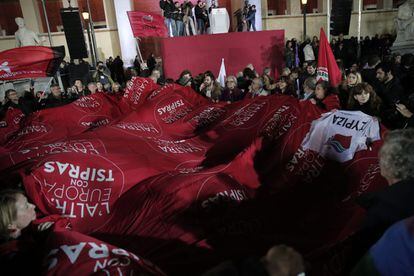 Los partidarios de Alexis Tsipras, líder de Syriza, ondean una bandera gigante frente a la Universidad de Atenas durante la alocución de su líder.