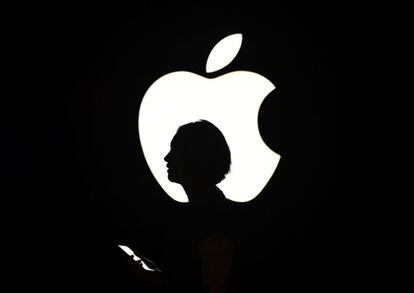 Una mujer pasa delante de un cartel con el logo de Apple en San Francisco, en septiembre de 2015.