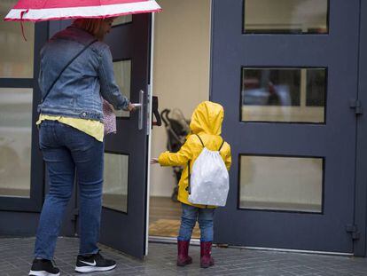 Una madre lleva a su hija a un colegio