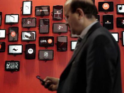 Un hombre consulta su m&oacute;vil ante el stand de Motorola del Mobile World Congress, en febrero de 2012, en Barcelona. 