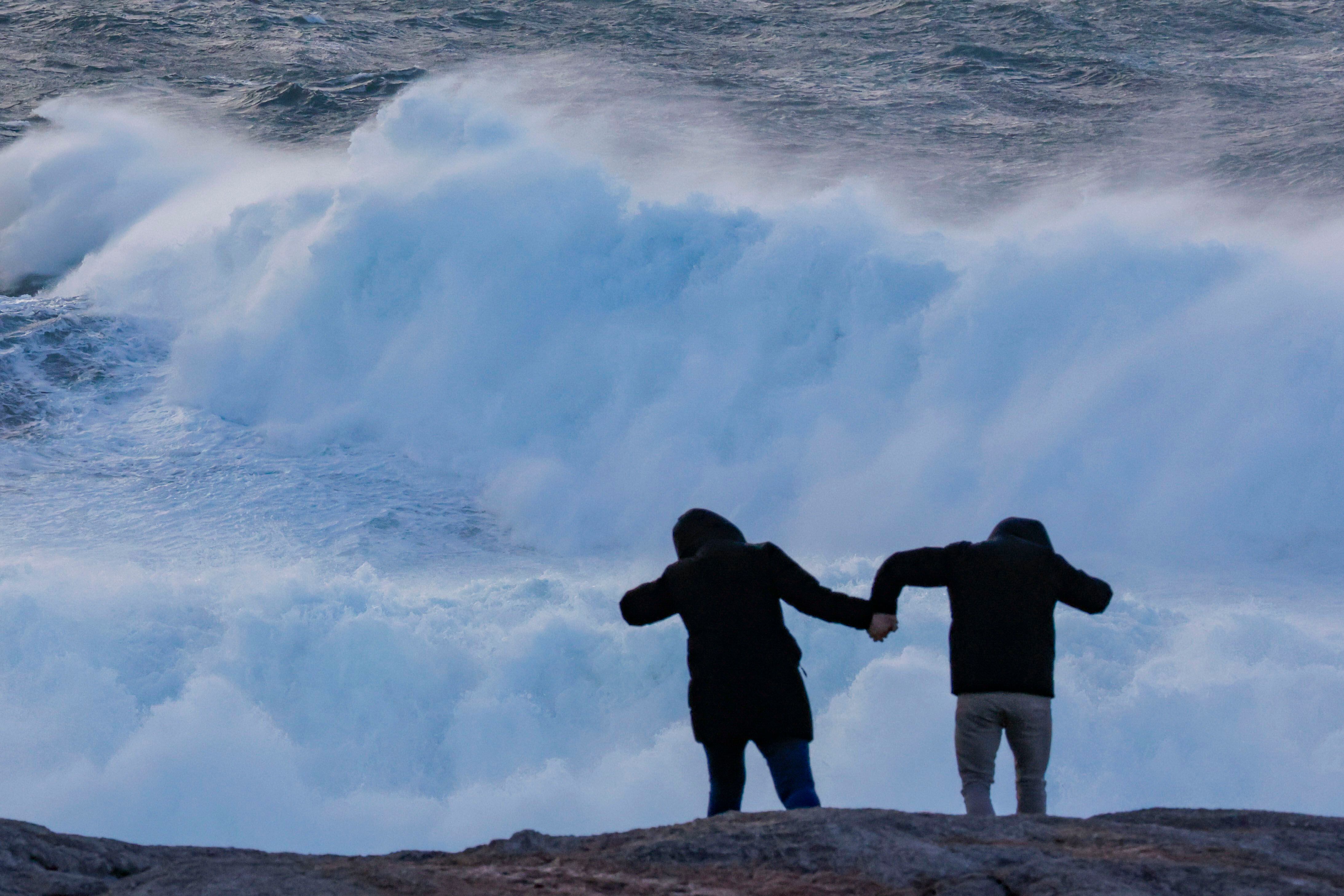 Dos turistas observan el oleaje en la cosa de Muxía (A Coruña), el miércoles.