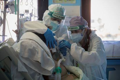 Una doctora y una enfermera de la Unidad de Cuidados Intensivos del Hospital Morales Meseguer de Murcia cambian el respirador a un paciente ingresado por covid-19, en enero de este año.