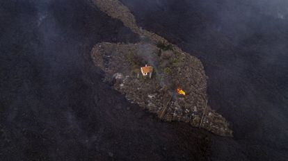 Vista aérea de una casa que permanece intacta mientras la lava fluye a su alrededor.