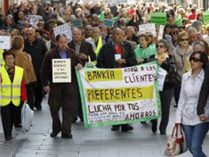 Un grupo de personas afectados por las participaciones preferentes de Bankia, a su paso por la plaza de Callao, durante una manifestación.