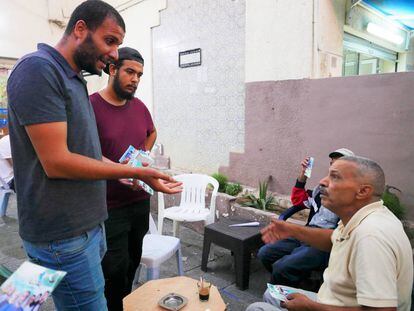 Amen Alá Jawhary intentando convencer a un anciano de que le vote en un café de Manuba.