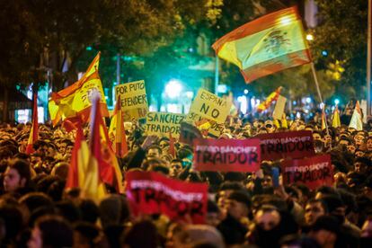 Pancartas contra el presidente del Gobierno, Pedro Sánchez, y banderas de España, durante la protesta en la calle de Ferraz. 