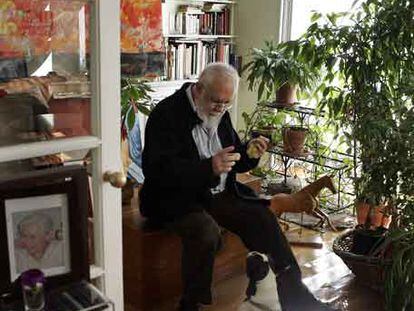 Gonzalo Suárez tienta con una uva a su perra <i>Margot</i> en el salón de su céntrica casa madrileña.