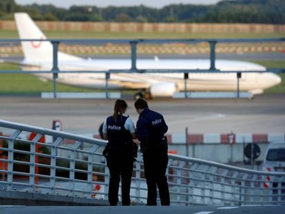 Agentes de la policía belga patrullan mientras que un avión aterriza en el aeropuerto de Zaventem (Bélgica).
 