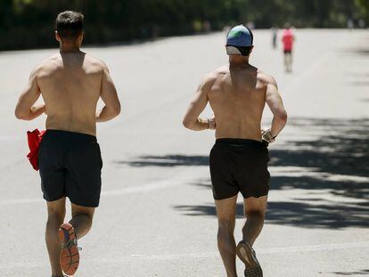 Dos hombres corren en el parque del Retiro de Madrid, con la ciudad en alerta amarilla por calor.