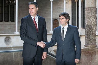 Xavier Garcia Albiol (i) y Carles Puigdemont (D) se saludan antes de la reuni&oacute;n este jueves.
 