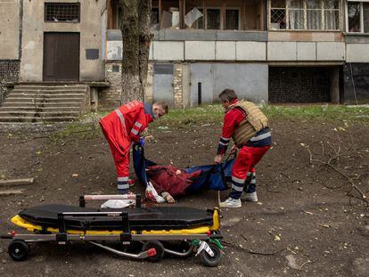 Trabajadores médicos recogen el cuerpo de una mujer, después de un bombardeo ruso en Járkov (Ucrania).