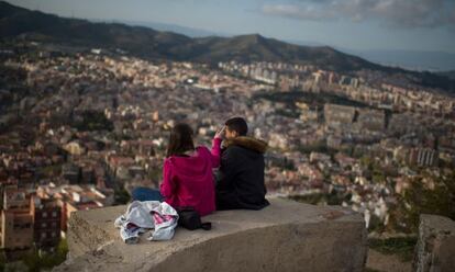 Una pareja observa Barcelona desde una antigua batería antiaérea de la Guerra Civil.