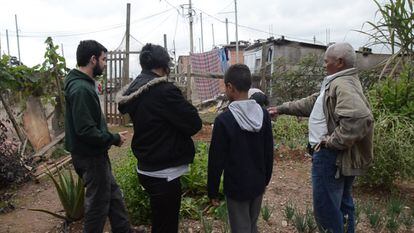 Lucas, Janaina y el Señor Inázio explican a uno de los 'meninos' de la Vila Nova Esperança las tareas pendientes de la huerta comunitaria.

