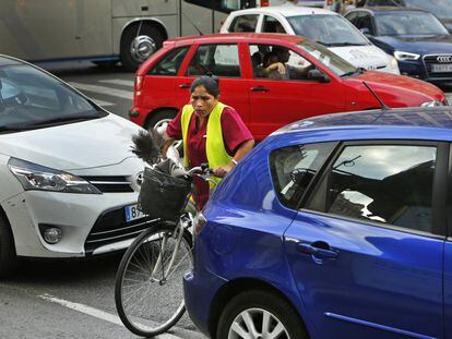 Una ciclista intenta cruzar entre los veh&iacute;culos en  el d&iacute;a europeo sin coches.