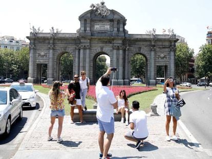 Varios turistas se fotografían ante Puerta de Alcalá, en el centro de Madrid