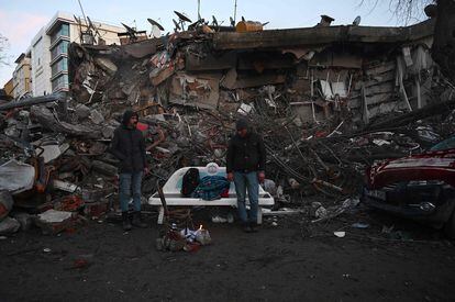 Dos hombres, junto a los escombros de un edificio colapsado en Kahramanmaras (Turquía). 