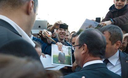 El presidente Hollande saluda a simpatizantes junto al Elíseo.