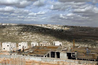 Unos obreros palestinos trabajan en las obras de construcción de un edificio de apartamentos en Jerusalén Este.