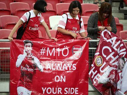 Un grupo de fans del Arsenal cuelgan un cartel de apoyo al alemán Mesut Özil durante el partido amistoso contra el Atlético de Madrid en el Estadio Nacional en Singapur.