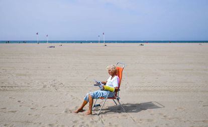 Una mujer lee en la playa de Deauville (Francia).