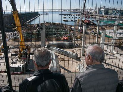Un grupo de jubilados observan unas obras junto al puerto de Barcelona