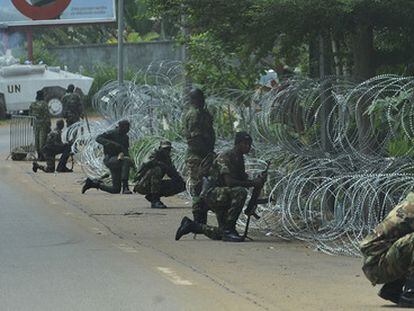 Soldados de las Fuerzas Nuevas, antiguos rebeldes partidarios de Ouattara, protegen el hotel donde se refugia el líder opositor, al tiempo que cascos azules patrullan la zona.