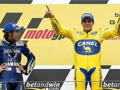 Valentino Rossi observa, brazos en jarras, la felicidad de Alex Barros en el peldaño superior del podio.