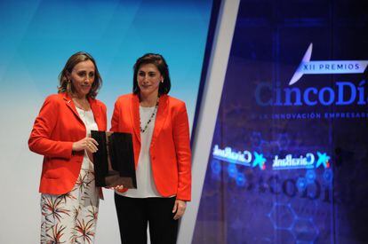 La directora ejecutiva de comunicación, RR II, marca y RSC de CaixaBank, María Luisa Martínez, entrega el premio a la iniciativa empresarial más innovadora en RSC a Eva Pagán, directora general de transporte de Red Eléctrica.