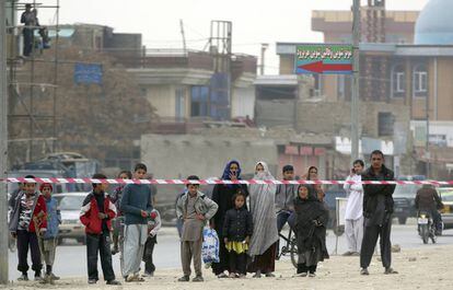Ciudadanos afganos observan la mezquita atacada desde detrás de la zona acordonada por la policía.
