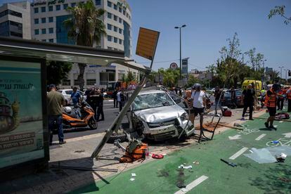 Las fuerzas de seguridad israelíes trabajan en el lugar de un ataque palestino con coche bomba en una parada de autobús en Tel Aviv, este martes.