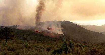 Un helicóptero trabaja en el incendio de Montán (Castellón).