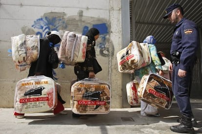 Fila de mujeres porteadoras marroquíes cargadas con mercancía desde Ceuta a Marruecos por el puente de Biutz.  