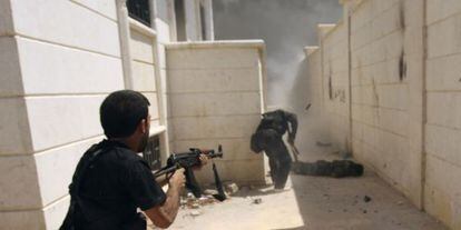 Un miembro del Ejército Libre de Siria cubre a un compañero durante una ofensiva en la ciudad de Khanasar, este lunes.