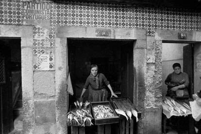 The fishmongers display their goods in stalls in the Alfama neighborhood, in the center of the city, under a poster of the Portuguese Communist Party.