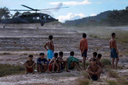 Hombres yanomamis miran el aterrizaje de un helicóptero de la Fuerza Aérea en el aeródromo de Surucucu, dentro del territorio de este grupo indígena.