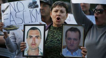 Una mujer sostiene los retrasos de dos fallecidos en Ucrania. 
