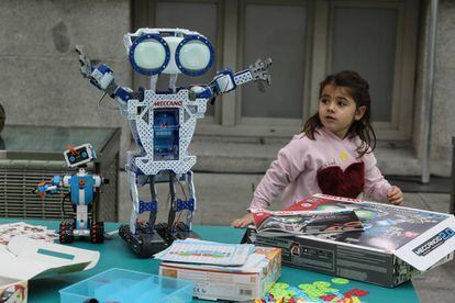 Una niña junto a dos de los robots mostrados en 'Me gusta jugar', en CentroCentro en Madrid.
