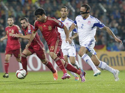 Diego Costa se escapa con el bal&oacute;n de dos defensores de Luxemburgo, con Paco Alc&aacute;cer tras &eacute;l.