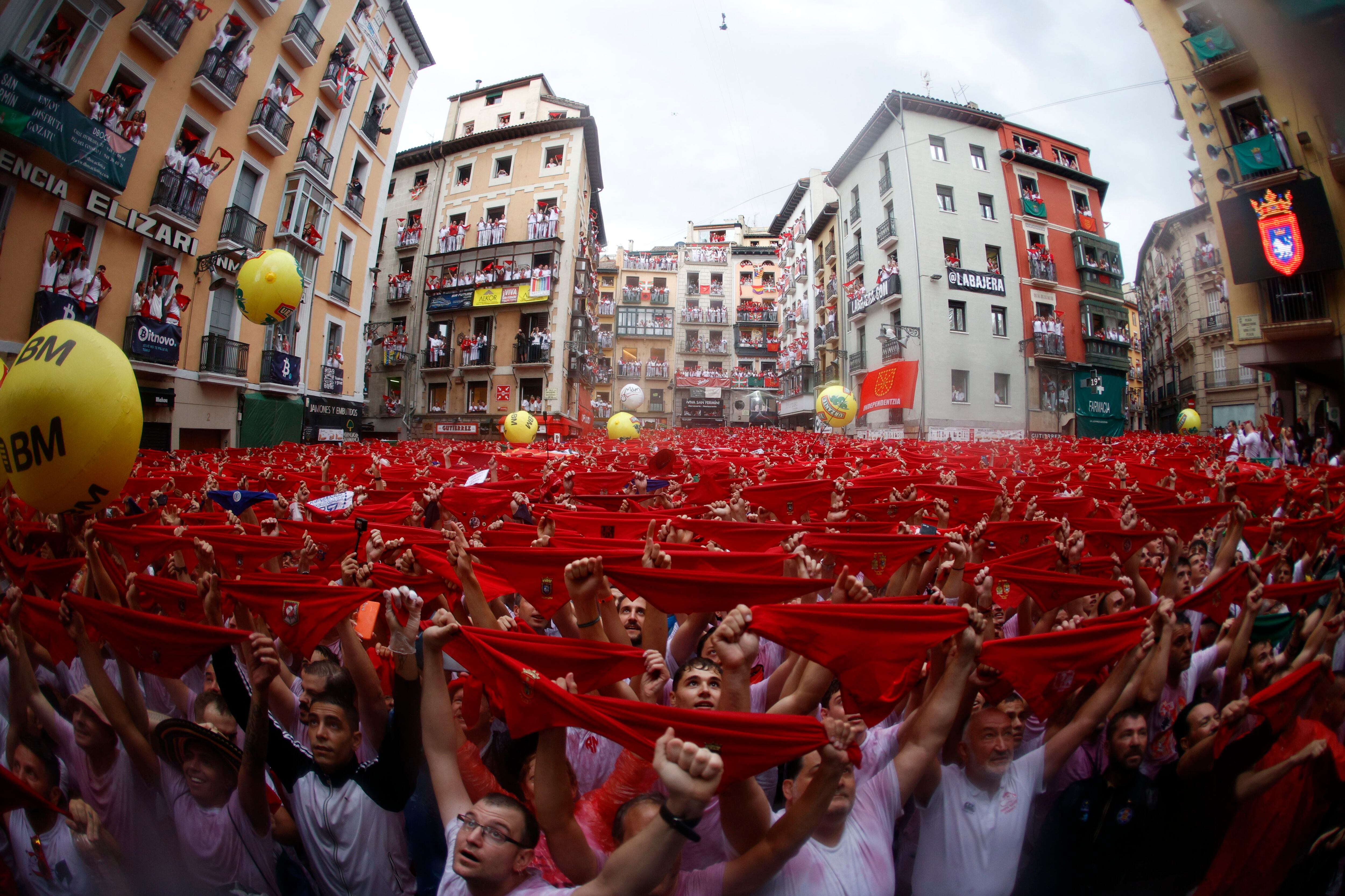 Cientos de personas alzan sus pañuelos durante el chupinazo en la plaza Consistorial de Pamplona. 