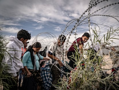 Migrantes venezolanos cruzan el alambrado colocado por la patrulla fronteriza de El Paso, Texas, desde Ciudad Juárez, Chihuahua.